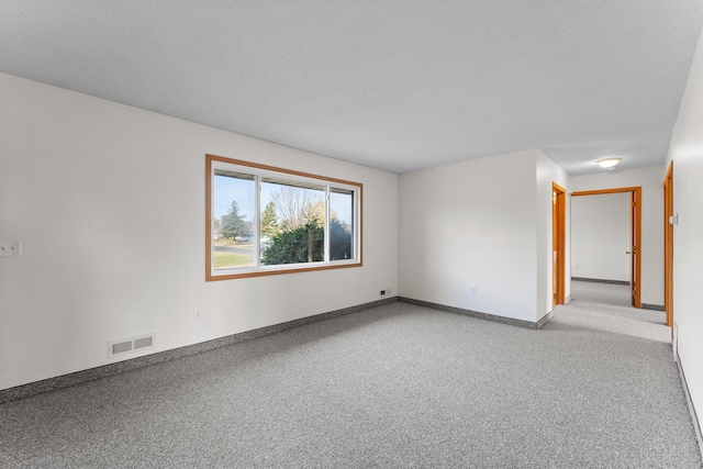 carpeted spare room with a textured ceiling