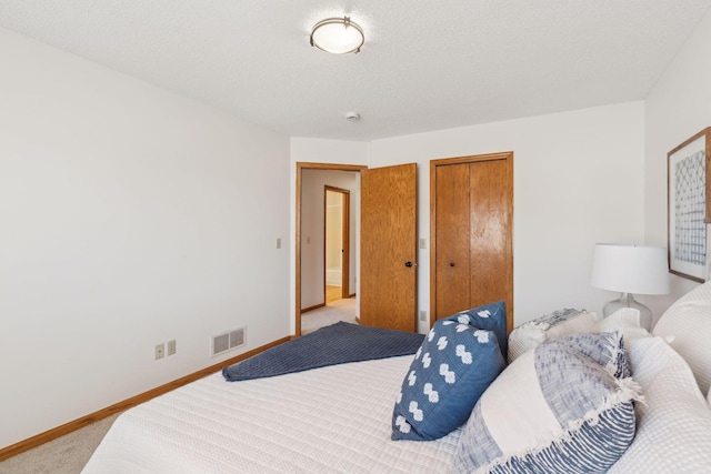 carpeted bedroom with a textured ceiling and a closet