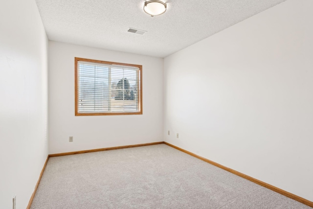 unfurnished room featuring carpet flooring and a textured ceiling