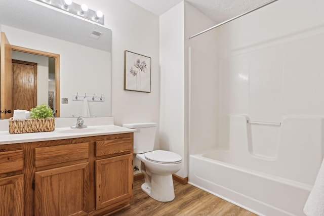 full bathroom with vanity, hardwood / wood-style floors, shower / bathing tub combination, and toilet