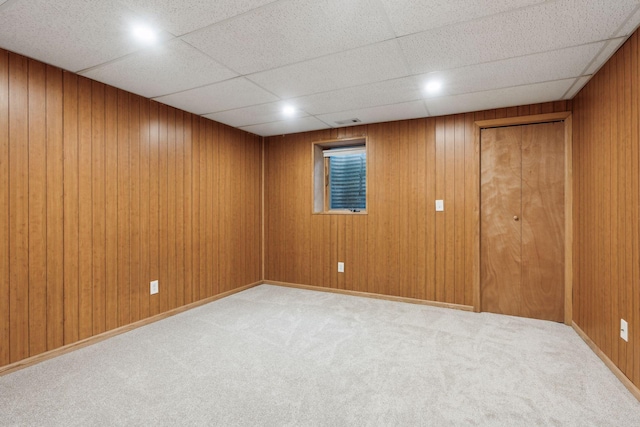 basement with light colored carpet and wooden walls