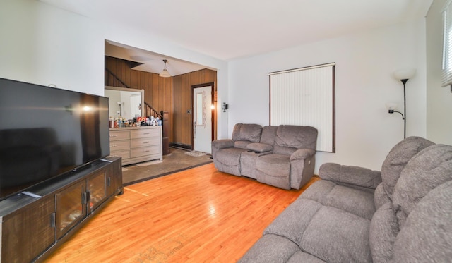 living room with wood-type flooring and wooden walls