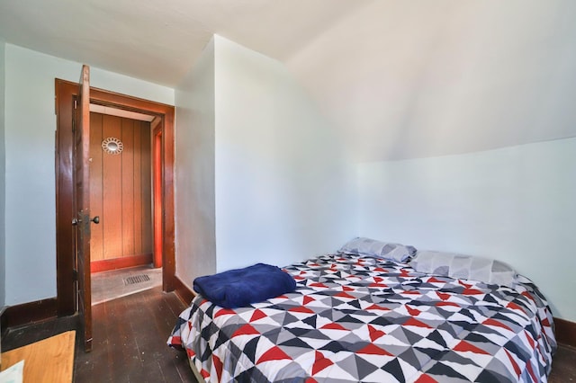 bedroom with dark hardwood / wood-style flooring and lofted ceiling