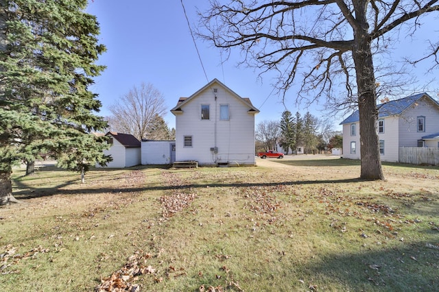 rear view of house featuring a lawn