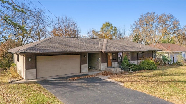 ranch-style house featuring a garage and a front yard