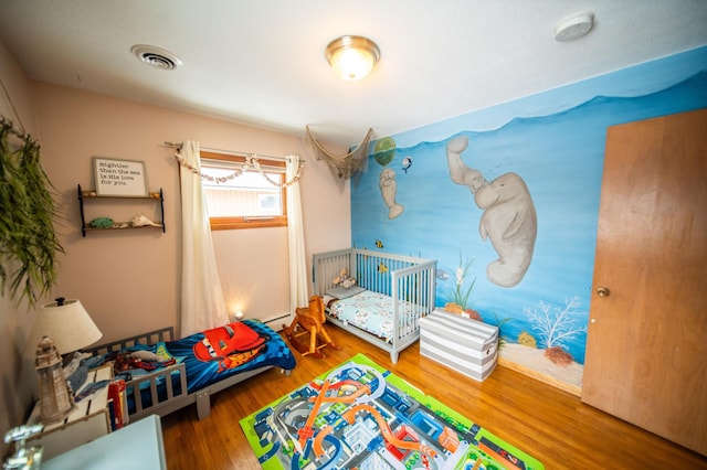 bedroom featuring visible vents and wood finished floors