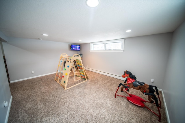 playroom featuring a textured ceiling, recessed lighting, a baseboard heating unit, baseboards, and carpet