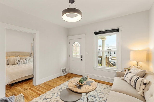 interior space featuring baseboards, visible vents, and light wood-style floors