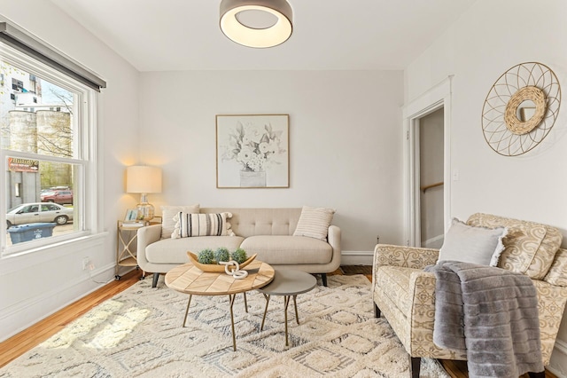 living area with baseboards and wood finished floors