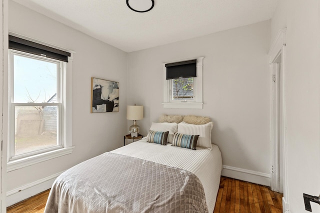 bedroom with baseboards and wood finished floors
