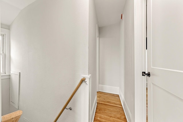hall with light wood-type flooring and baseboards