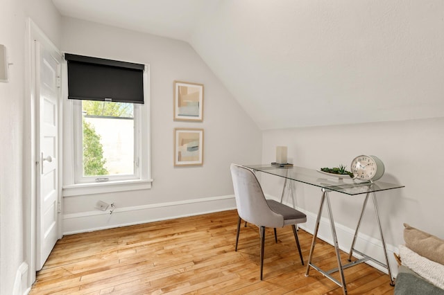 office space featuring wood-type flooring, baseboards, and lofted ceiling