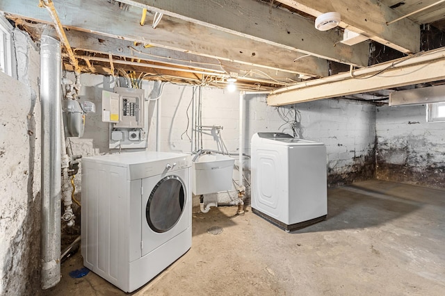 laundry area featuring laundry area, a sink, electric panel, and washing machine and clothes dryer
