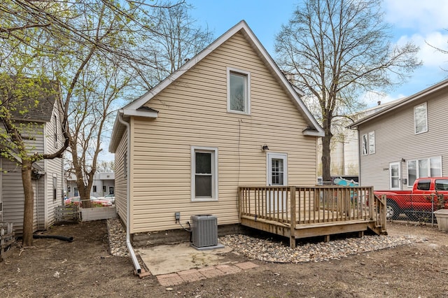 rear view of property with fence, central AC unit, and a wooden deck