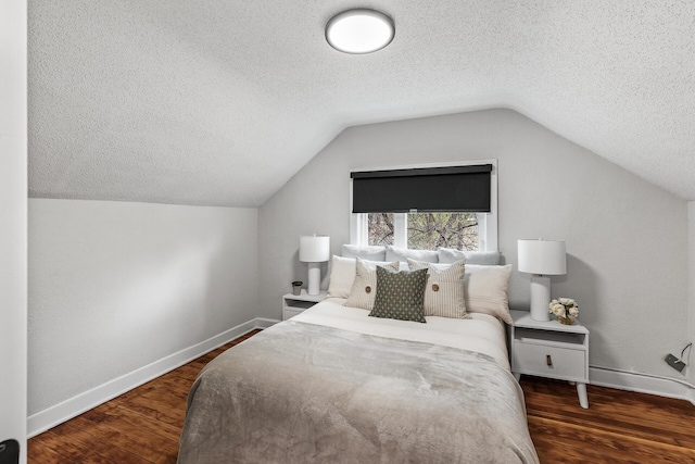 bedroom with vaulted ceiling, a textured ceiling, baseboards, and wood finished floors