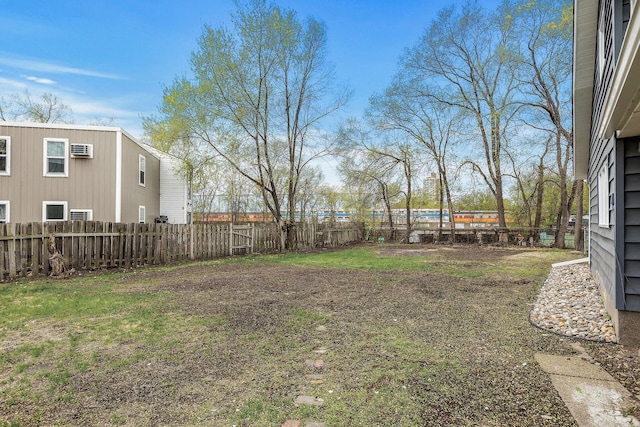 view of yard featuring a wall mounted air conditioner and a fenced backyard