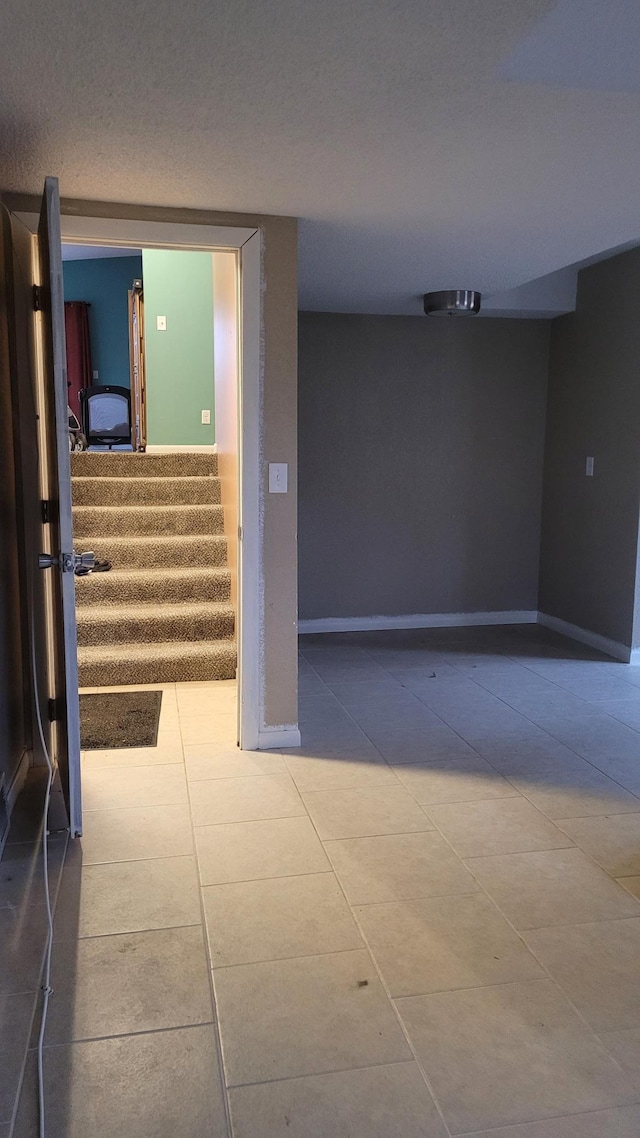 corridor with tile patterned floors and a textured ceiling