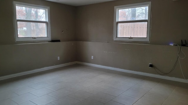 tiled spare room featuring plenty of natural light