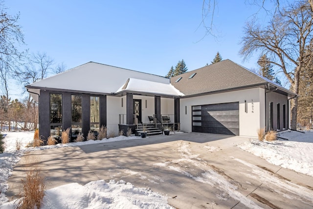 view of front of house with driveway, an attached garage, and stucco siding