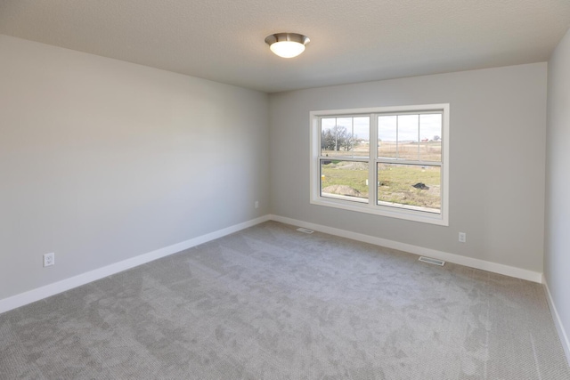 carpeted spare room featuring a textured ceiling