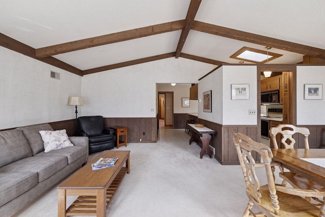 living area with visible vents, wainscoting, light colored carpet, and lofted ceiling with beams