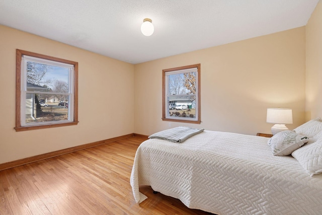 bedroom with baseboards and light wood finished floors