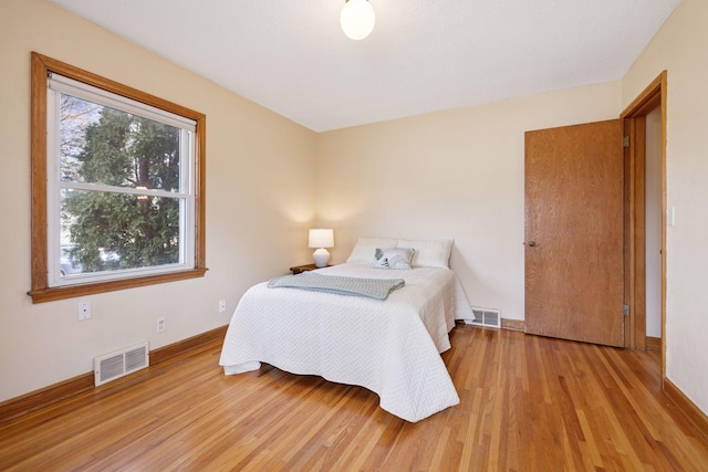 bedroom featuring visible vents, baseboards, and light wood-style floors