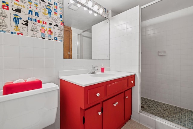 full bathroom with vanity, toilet, tile walls, and a shower stall