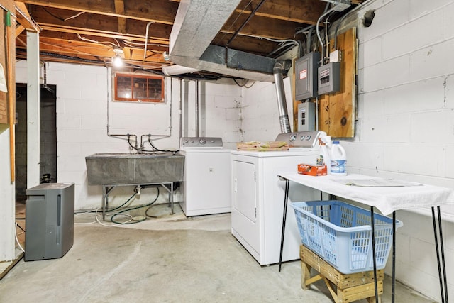 clothes washing area with washing machine and clothes dryer, laundry area, electric panel, and a sink