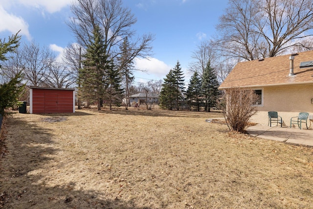 view of yard with an outbuilding, a shed, and a patio