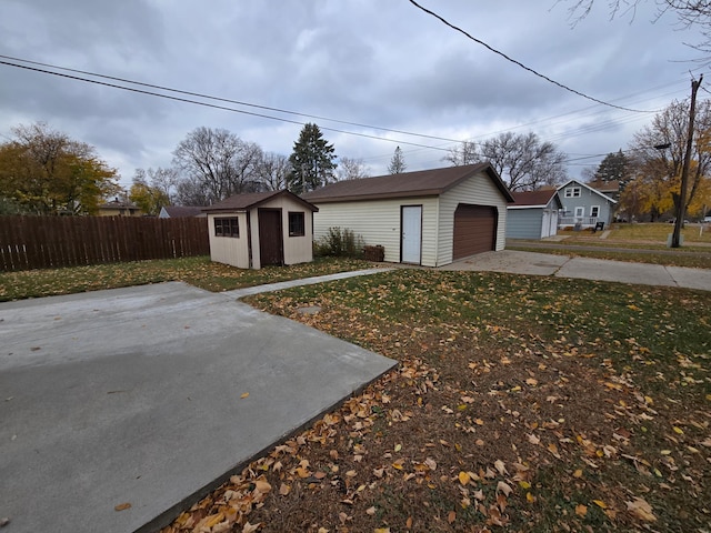 view of front of property with a front lawn, a storage unit, and a garage