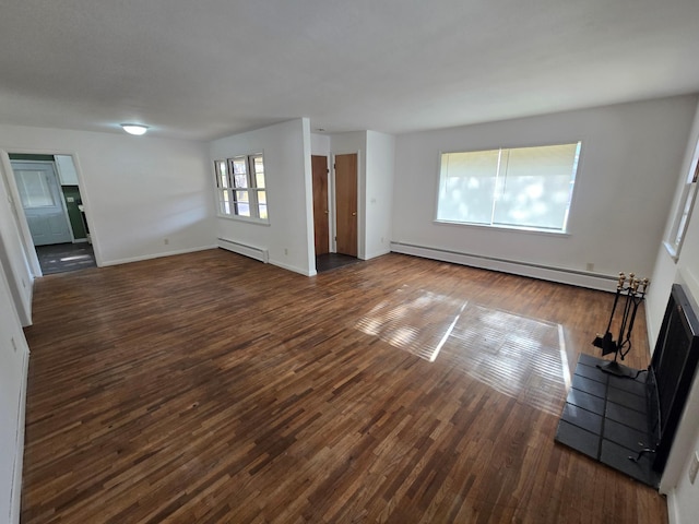 unfurnished living room featuring dark hardwood / wood-style flooring and a baseboard heating unit