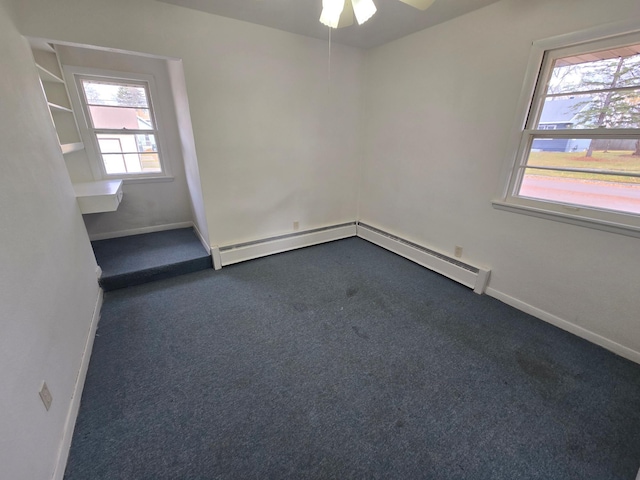 carpeted spare room with baseboard heating, a healthy amount of sunlight, and ceiling fan