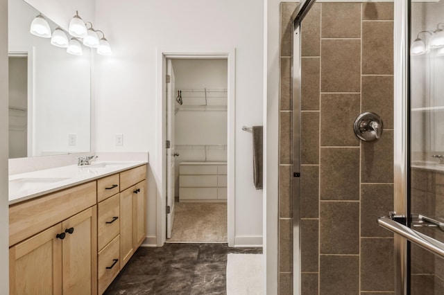 bathroom featuring a shower with door and vanity