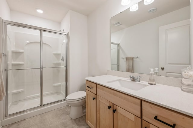 bathroom with a shower with shower door, vanity, toilet, and tile patterned flooring