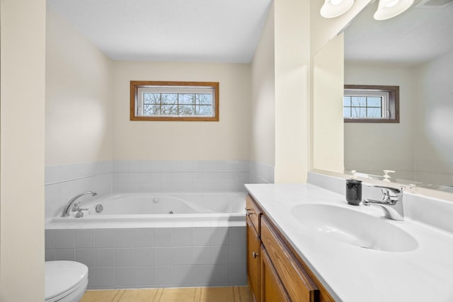 bathroom with vanity, tile patterned flooring, toilet, a textured ceiling, and tiled tub