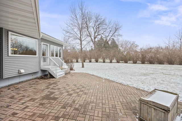 yard layered in snow with a patio area