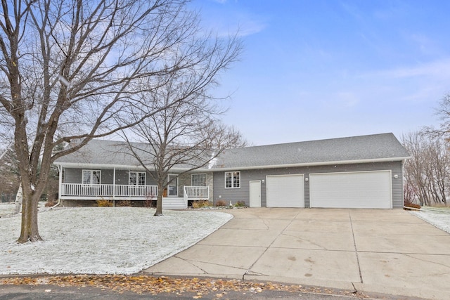 view of front of house with a garage, covered porch, and driveway