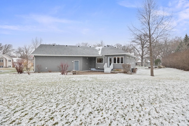 rear view of house with entry steps and roof with shingles