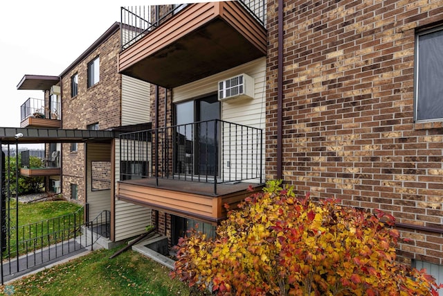 exterior space with a wall unit AC and a balcony