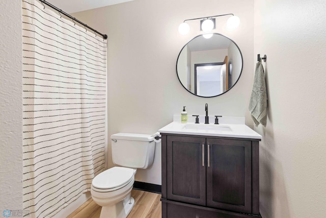 bathroom featuring toilet, vanity, hardwood / wood-style flooring, and walk in shower