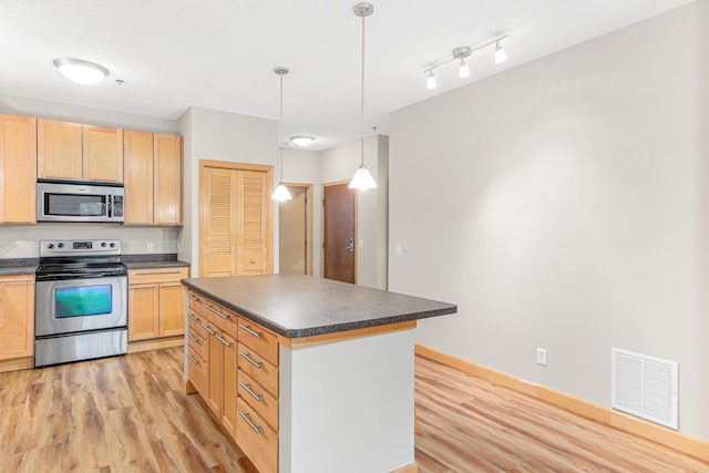 kitchen featuring light wood-type flooring, appliances with stainless steel finishes, decorative light fixtures, light brown cabinets, and a center island