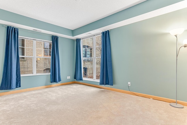 carpeted spare room with a textured ceiling