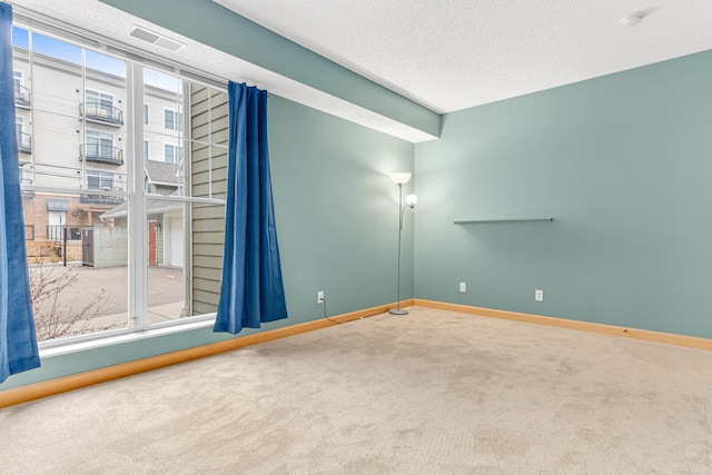 unfurnished room featuring carpet flooring and a textured ceiling