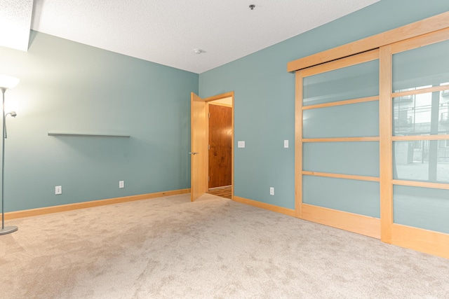 carpeted empty room with a textured ceiling