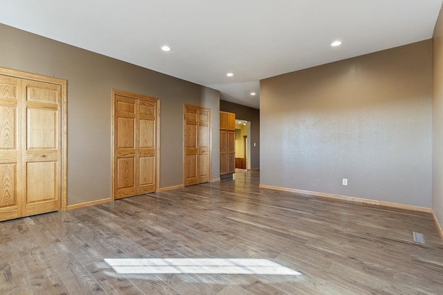 interior space with multiple closets and light wood-type flooring