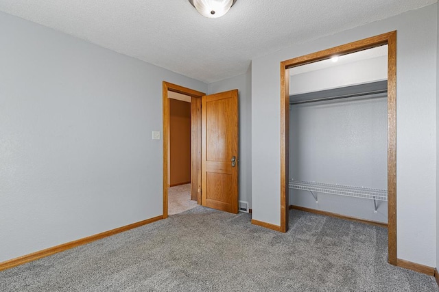 unfurnished bedroom featuring light colored carpet, a textured ceiling, and a closet