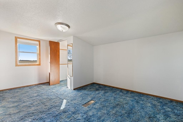 bonus room featuring carpet and a textured ceiling