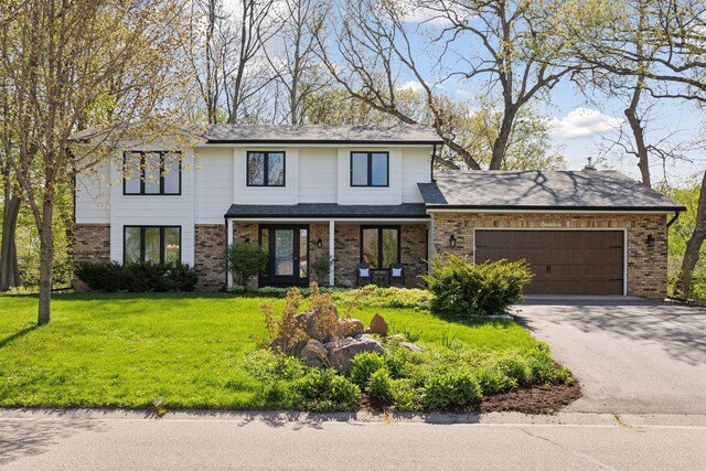 view of front of home with a garage, a front yard, aphalt driveway, and brick siding