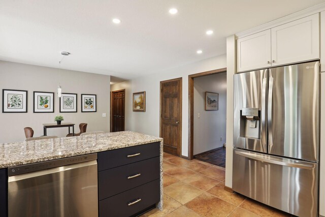 kitchen with light stone counters, dark cabinets, recessed lighting, white cabinetry, and appliances with stainless steel finishes